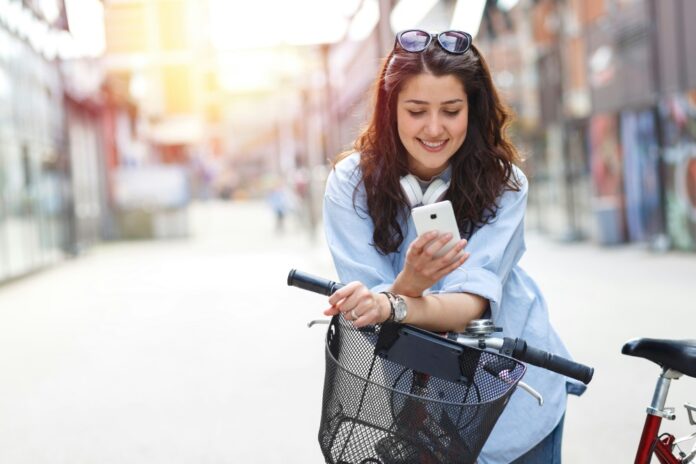 a woman take a break on phone while lying to the bike